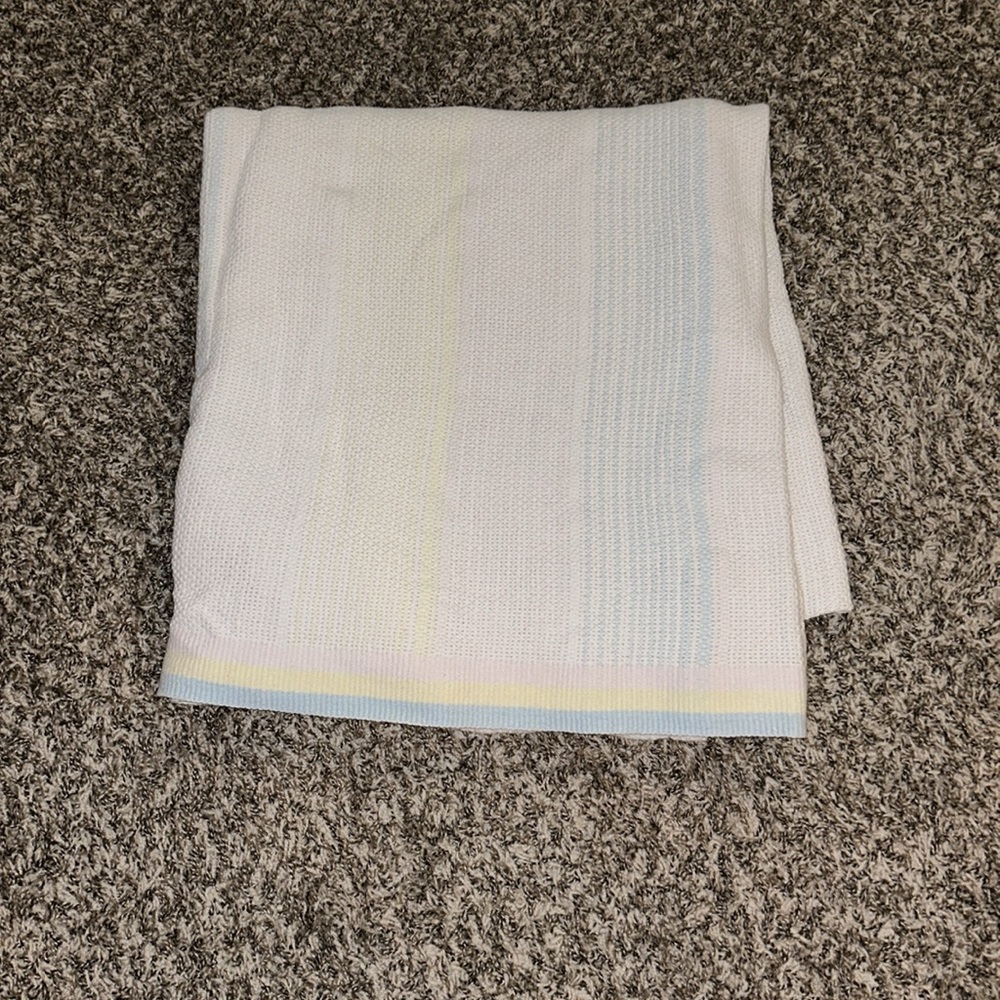 White, Pink, Blue, and Yellow Blanket
